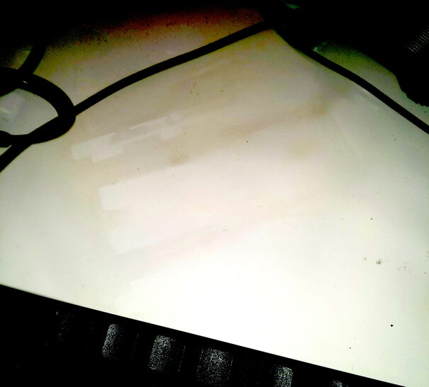 Desk surface with a faint outline of a drive in soot